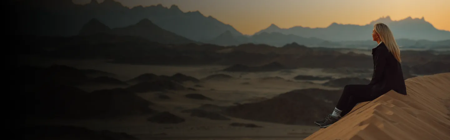 Woman Silhouetted at Sunset in Desert Horizon